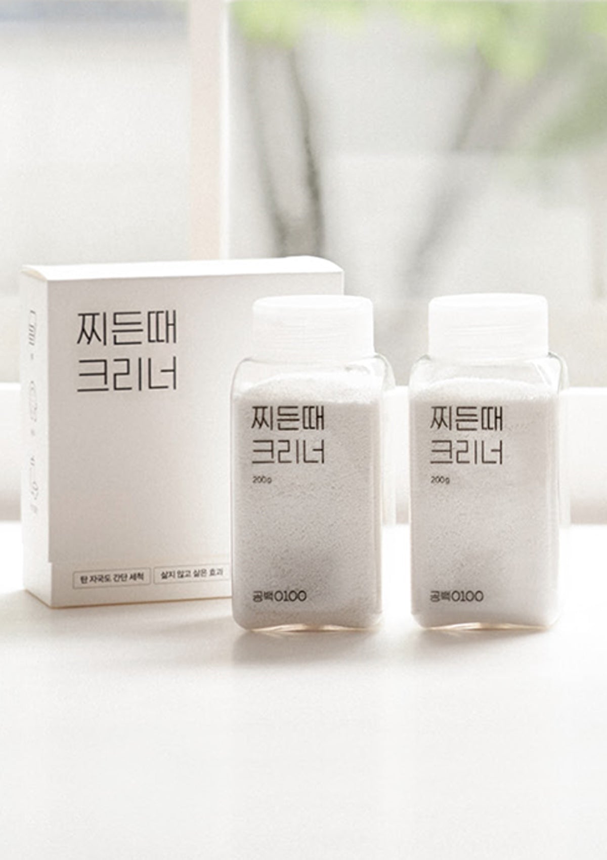 Two bottles and a box of skincare product on a white background